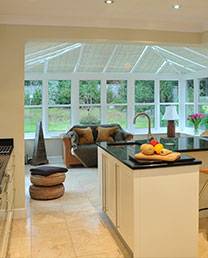 new white conservatory installation with view from the kitchen