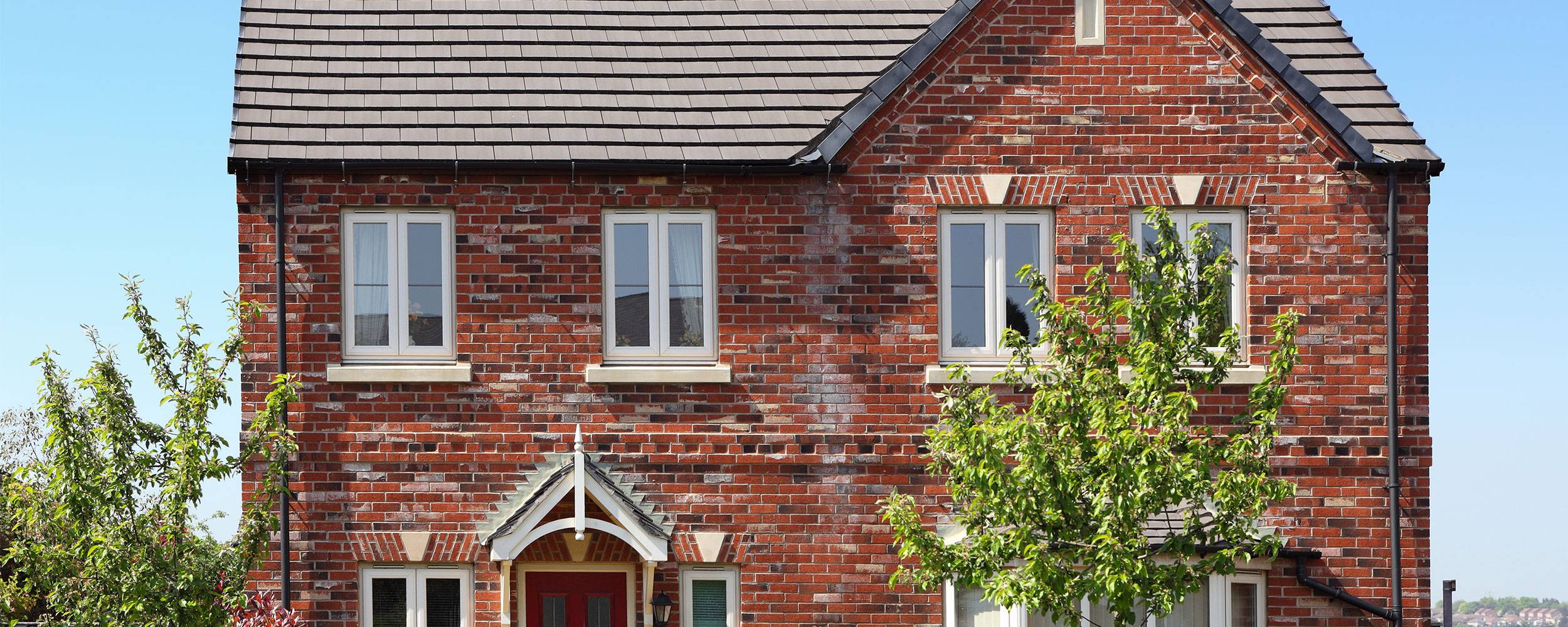 Red brick house with new white window installations